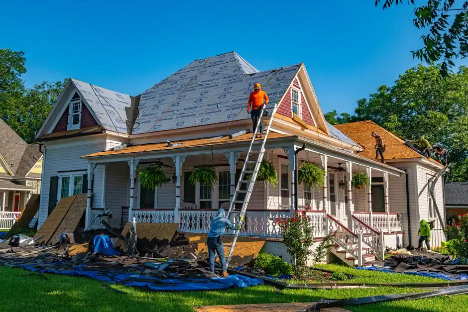 Roofers replace the roof of a historic home in Weatherford, Texas.